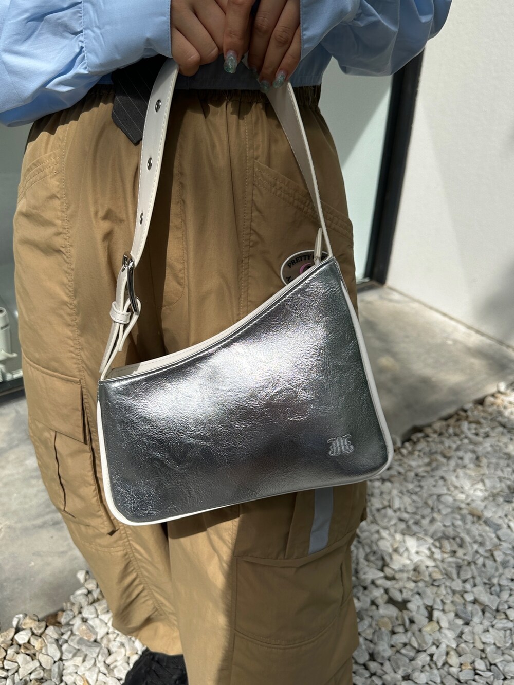 ベージュ系のカーゴパンツ、ブラック系のスニーカー、シルバー系のハンドバッグを着用したレディースの春コーディネートの10枚目の写真