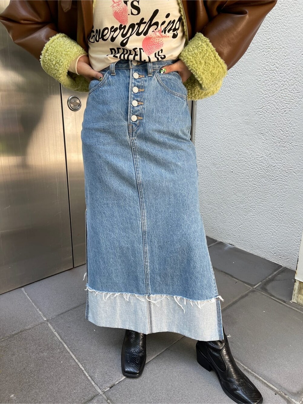 ブラック系のブーツ、ブラウン系のその他アウター、ブルー系のデニムスカートを着用したレディースの夏コーディネートの9枚目の写真