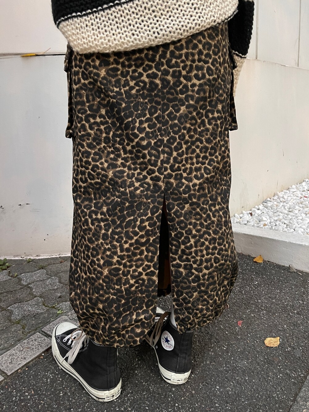 ブラウン系のスカート、ブラック系のニット/セーター、ブラック系のスニーカーを着用したレディースの秋コーディネートの8枚目の写真