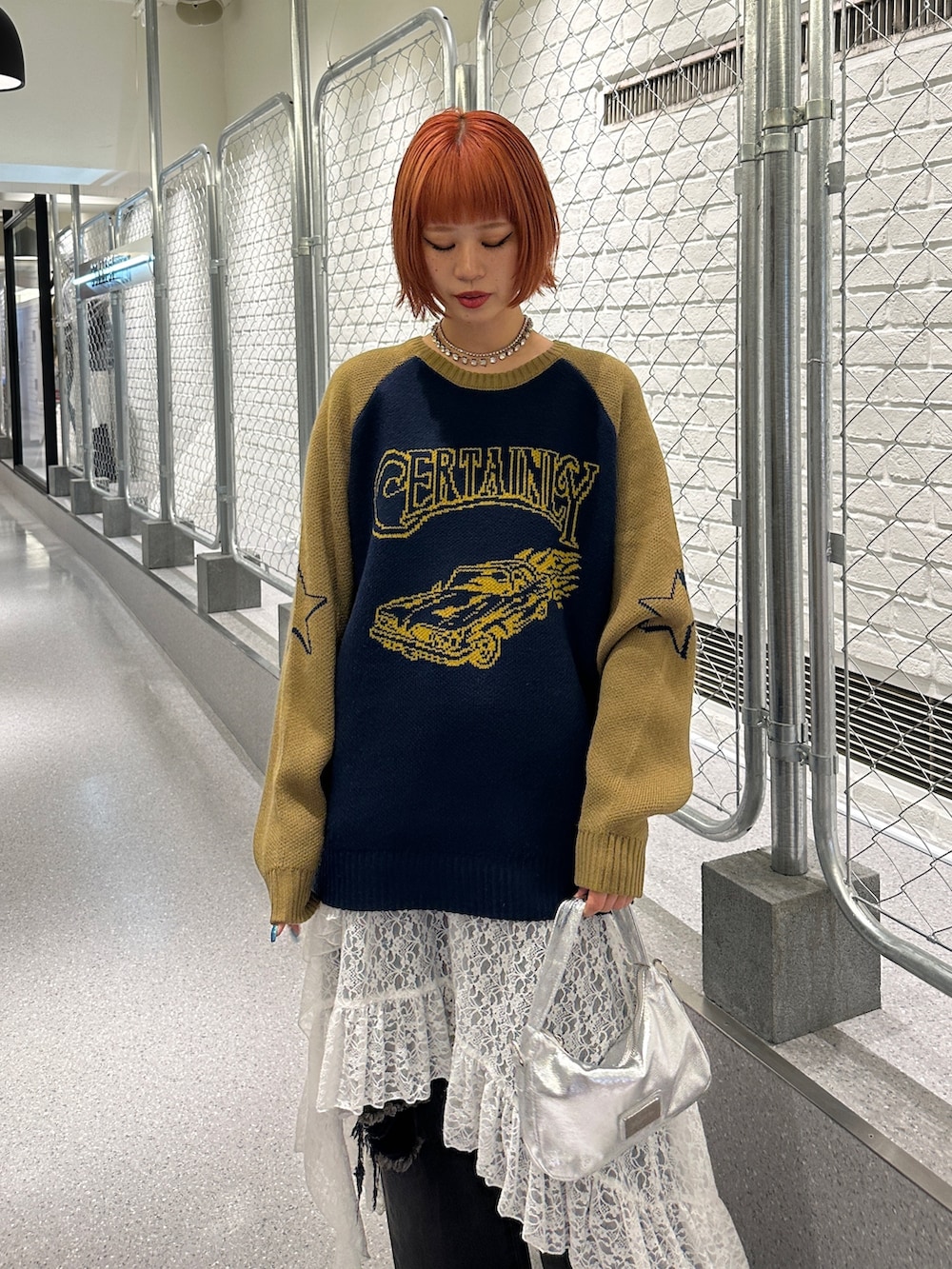 ブルー系のニット/セーター、ホワイト系のスカート、ブラック系のデニムパンツを着用したレディースの冬コーディネートの7枚目の写真