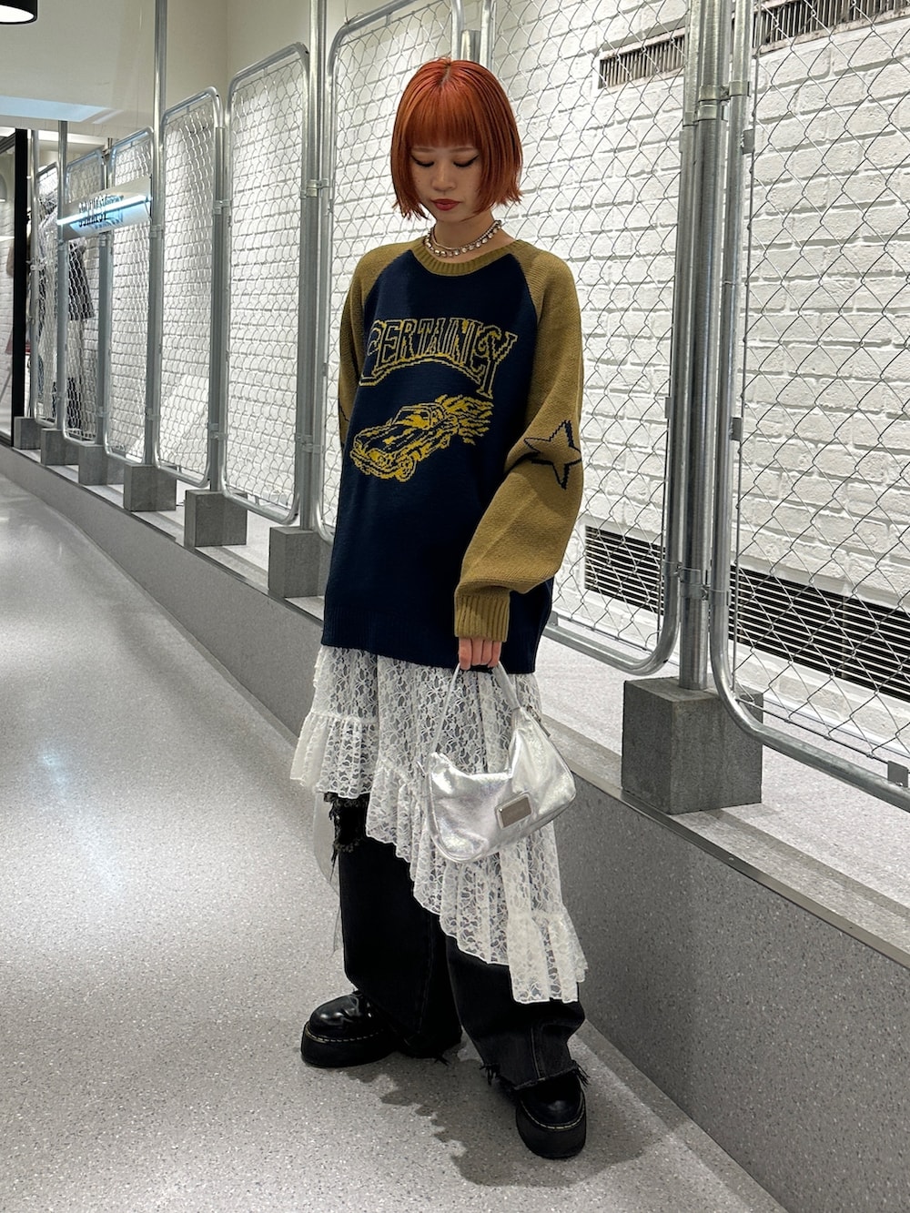 ブルー系のニット/セーター、ホワイト系のスカート、ブラック系のデニムパンツを着用したレディースの冬コーディネートの5枚目の写真