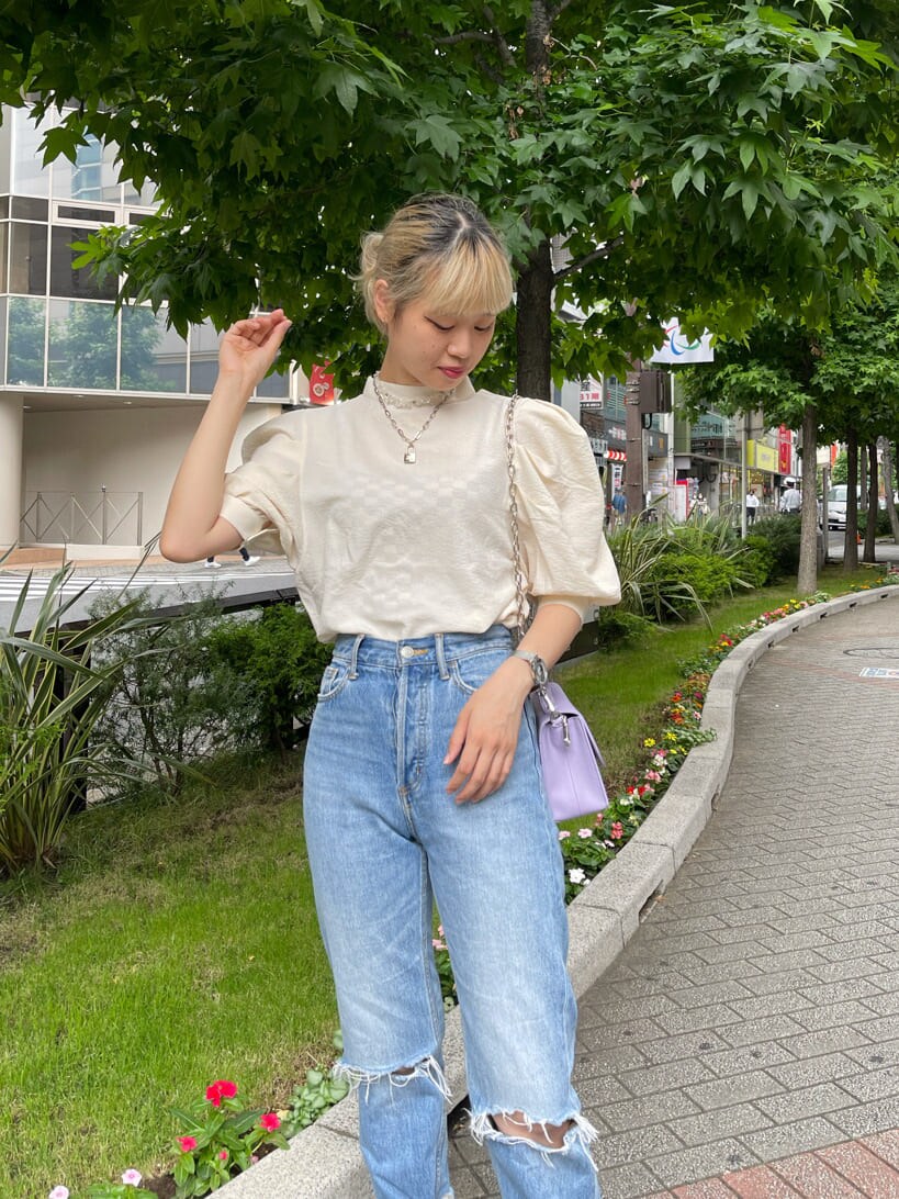 パープル系のショルダーバッグ、ホワイト系のシャツ/ブラウス、ブルー系のデニムパンツを着用したレディースの夏コーディネートの4枚目の写真
