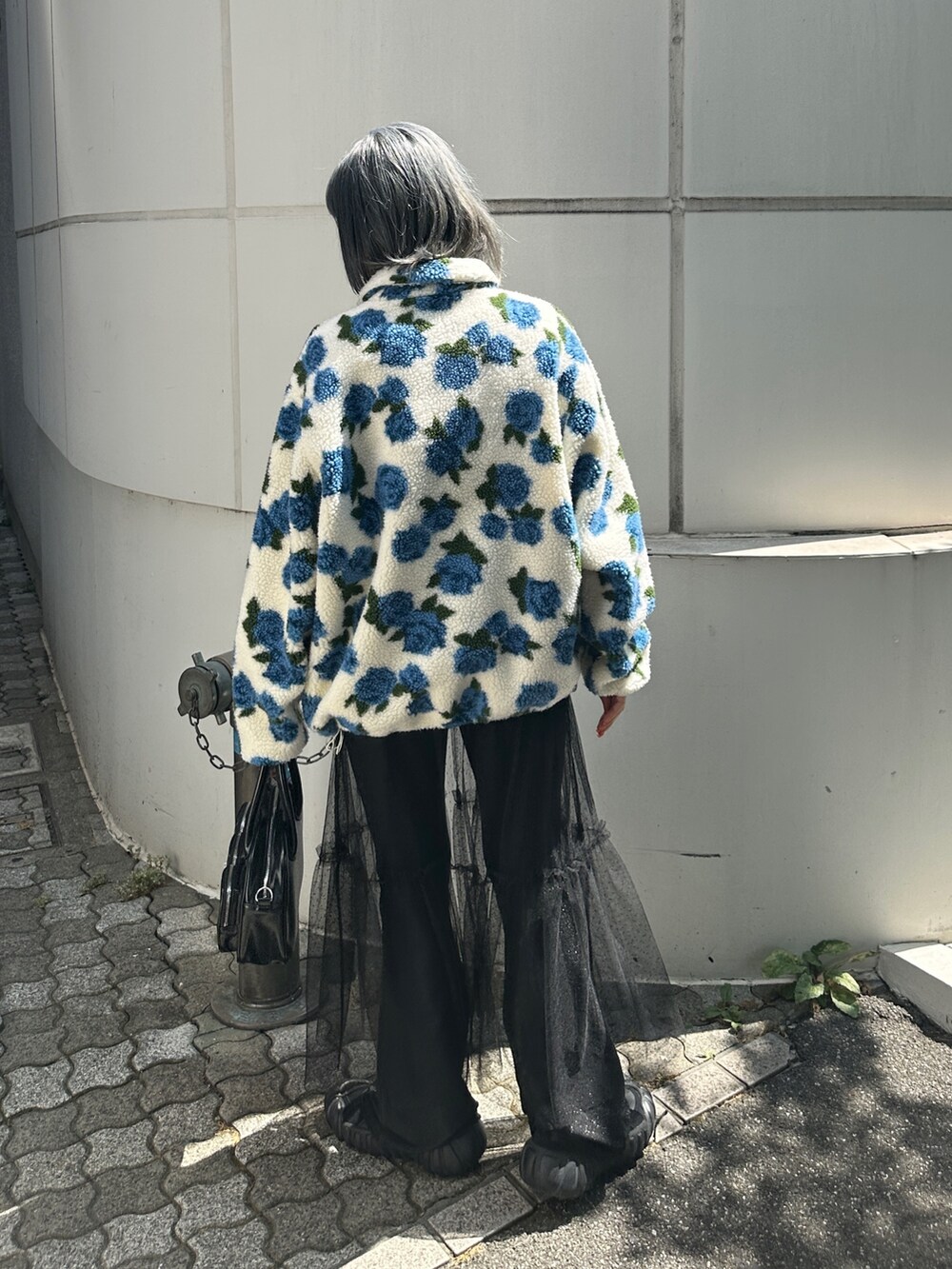 ホワイト系のブルゾン、ブラック系のワンピース、ブラック系のボストンバッグを着用したレディースの夏コーディネートの4枚目の写真