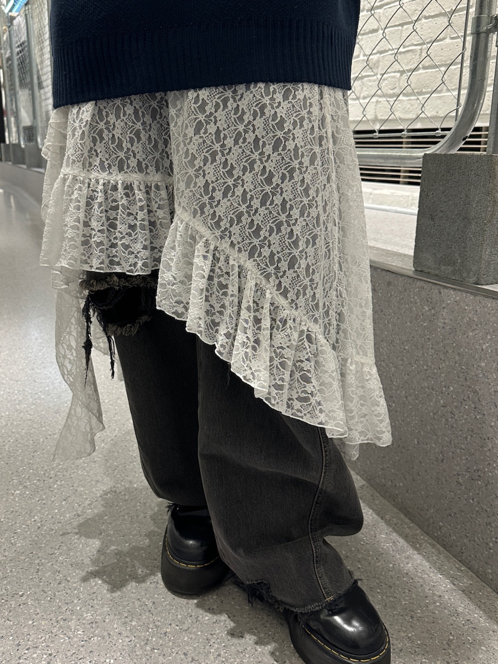 ブルー系のニット/セーター、ホワイト系のスカート、ブラック系のデニムパンツを着用したレディースの冬コーディネートの10枚目の写真