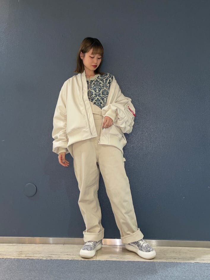 ホワイト系のMA-1、ホワイト系のスニーカー、ホワイト系のサロペット/オーバーオールを着用したレディースの冬コーディネートの3枚目の写真