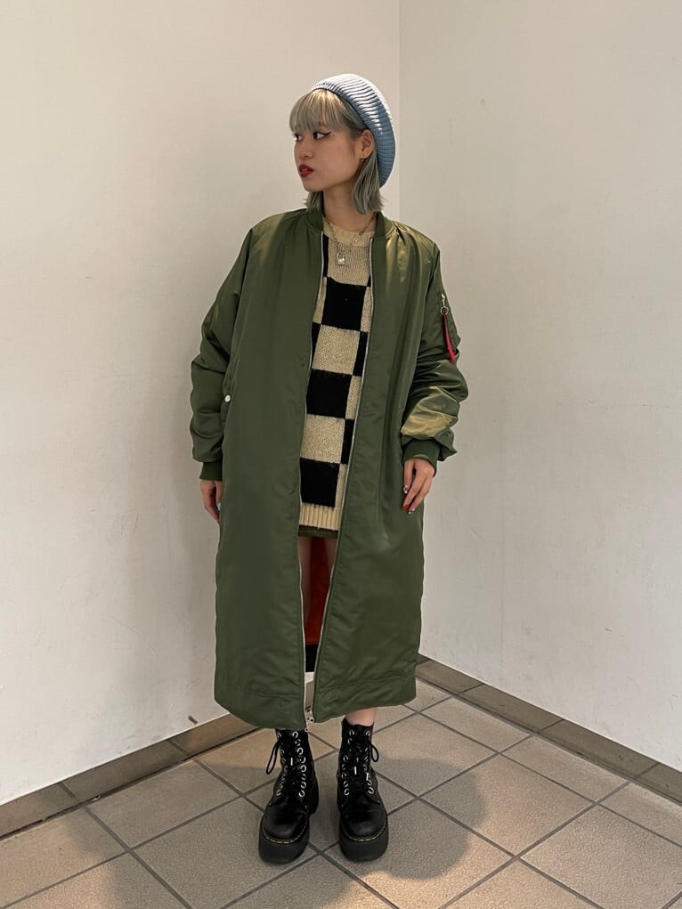 ブラック系のニット/セーター、グリーン系のMA-1、グリーン系のスカートを着用したレディースの秋コーディネートの2枚目の写真