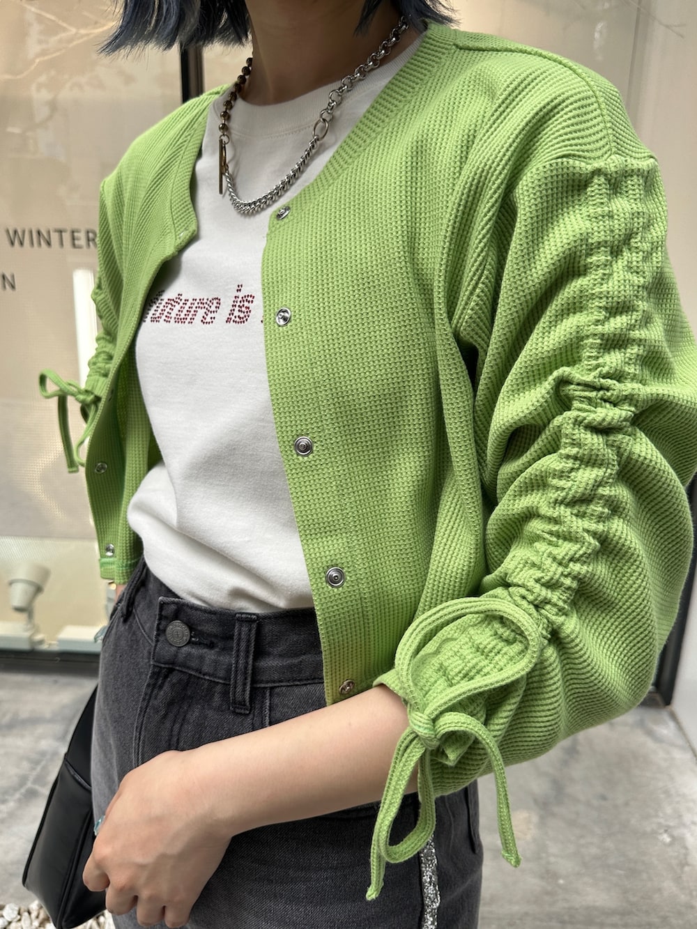 グリーン系のTシャツ/カットソー、ブラック系のデニムパンツ、ブラック系のハンドバッグを着用したレディースの夏コーディネートの6枚目の写真