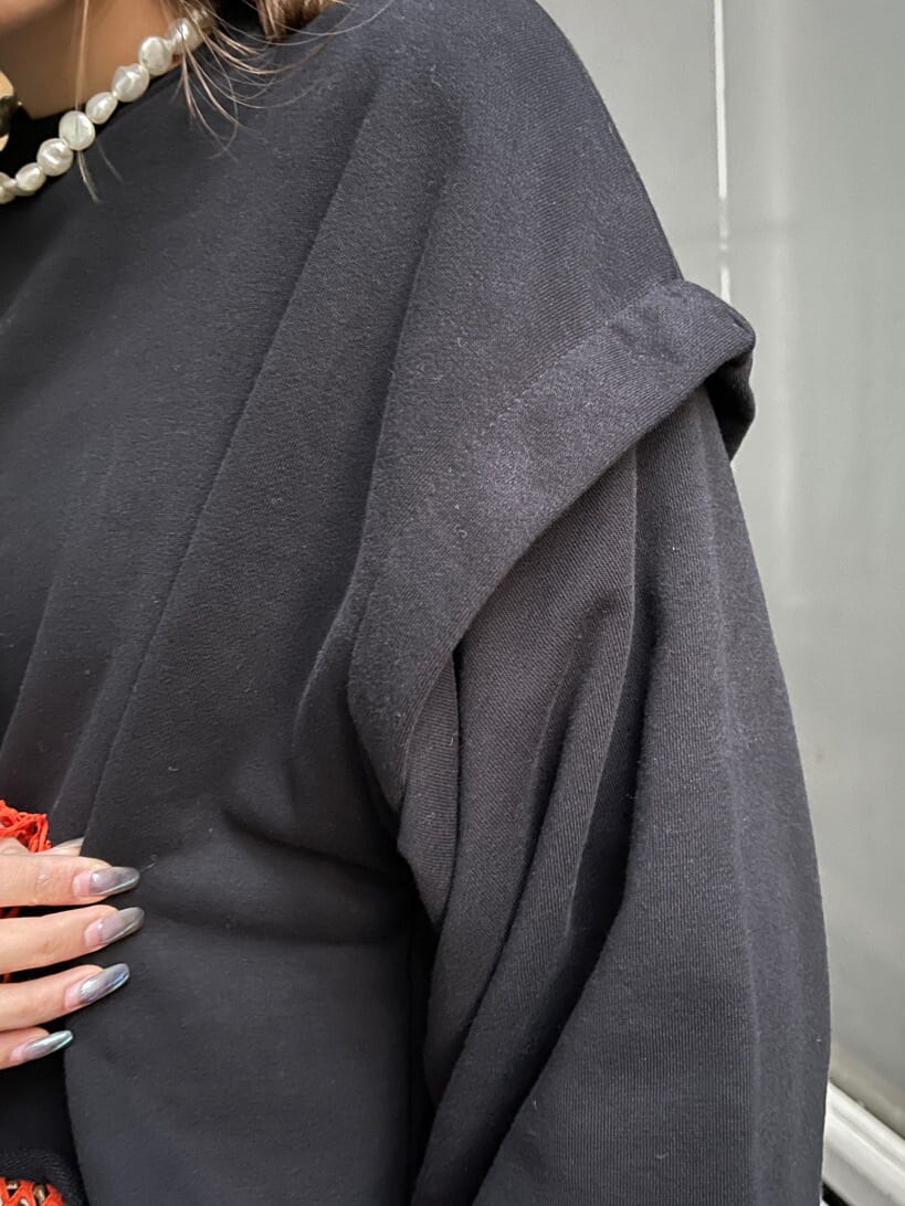 ブラック系のブーツ、ブラック系のTシャツ/カットソー、オレンジ系のTシャツ/カットソーを着用したレディースの冬コーディネートの10枚目の写真