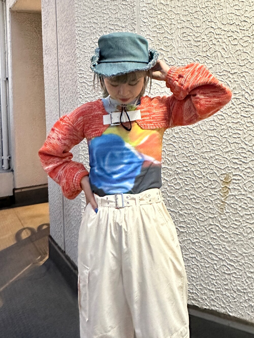 イエロー系のその他パンツ、オレンジ系のニット/セーター、ブラック系のTシャツ/カットソーを着用したレディースの冬コーディネートの5枚目の写真