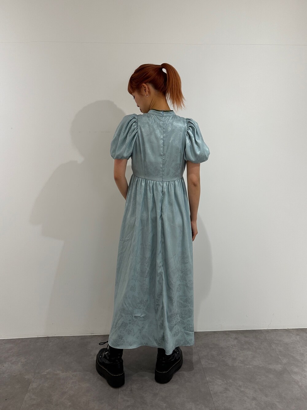 ブルー系のワンピース、ブラック系のブーツを着用したレディースの春コーディネートの3枚目の写真