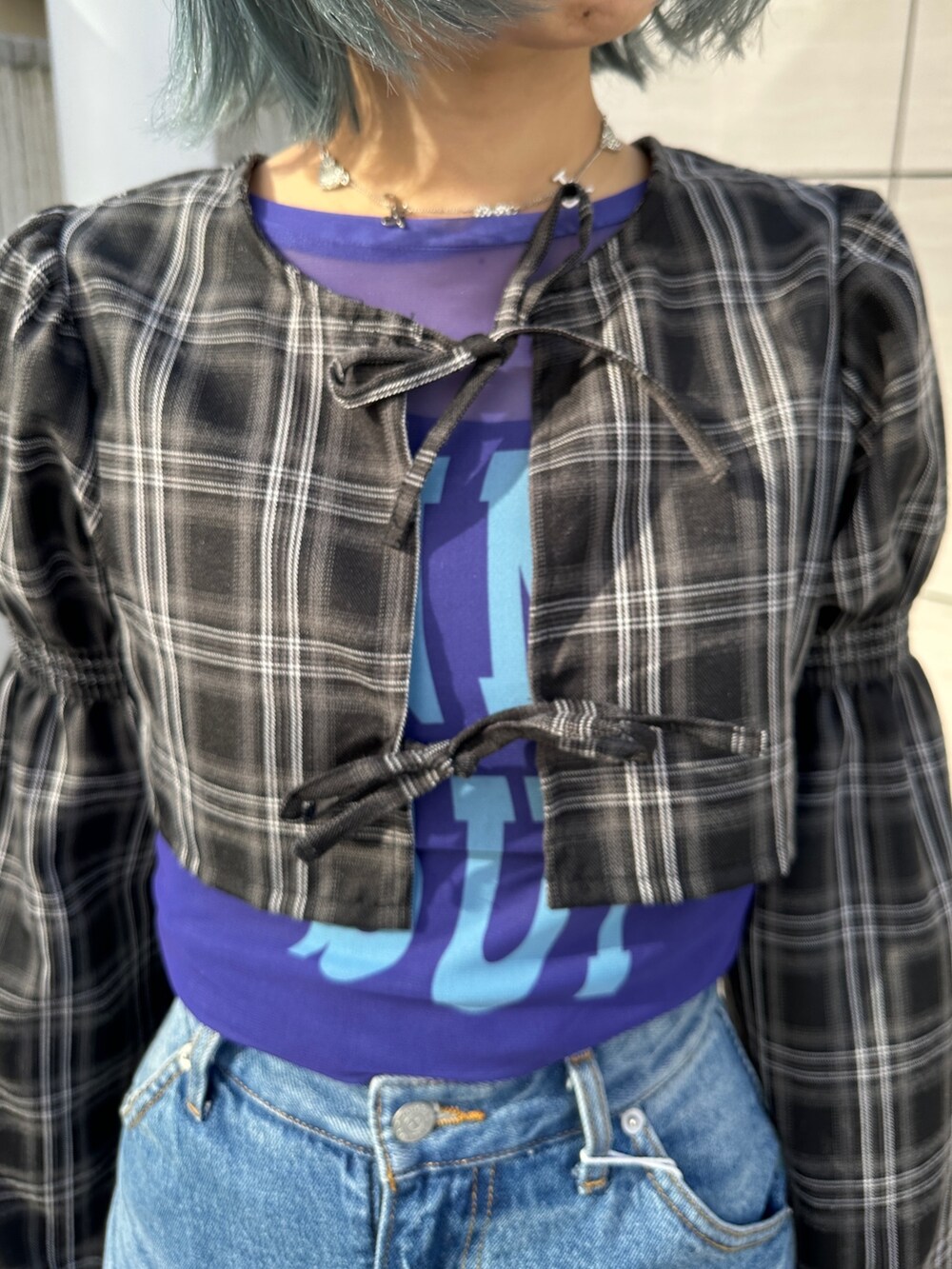 ブルー系のスカート、パープル系のTシャツ/カットソー、ブラック系のワンピースを着用したレディースの冬コーディネートの6枚目の写真