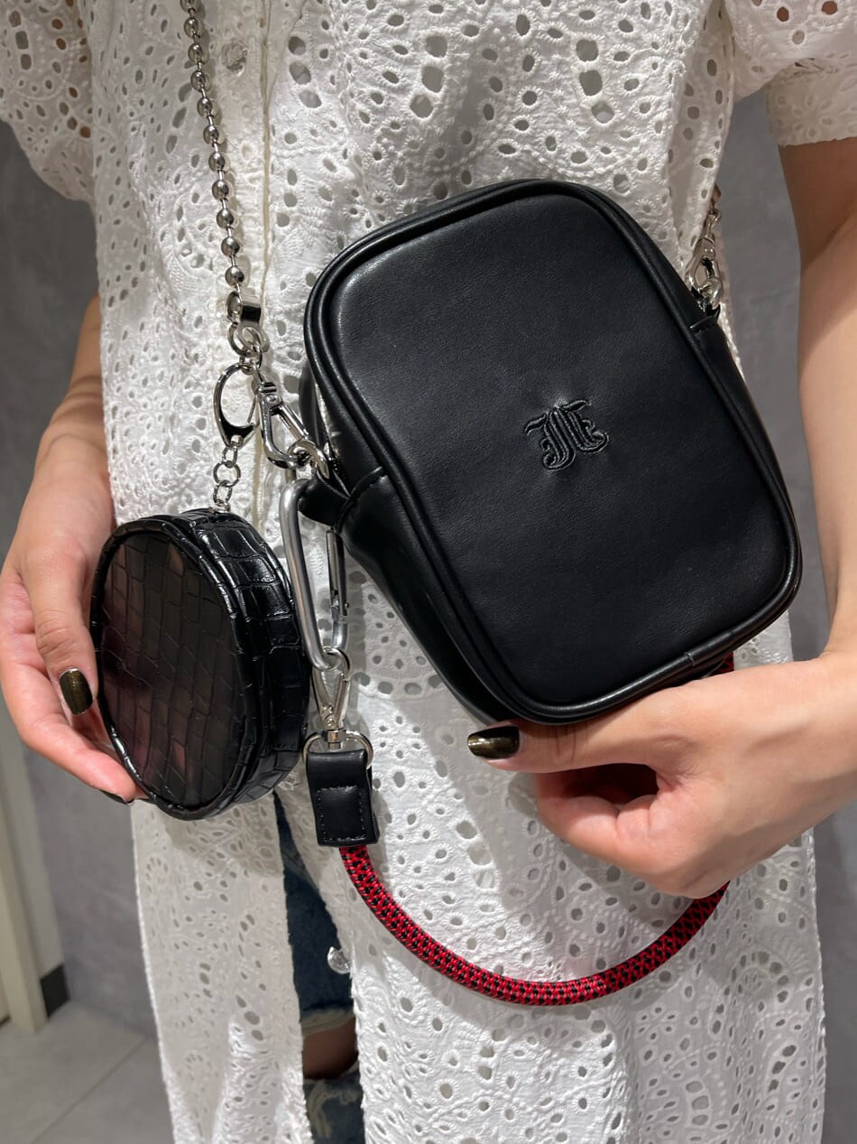 ホワイト系のワンピース、ブルー系のデニムパンツ、ブラウン系のショルダーバッグを着用したレディースの夏コーディネートの7枚目の写真