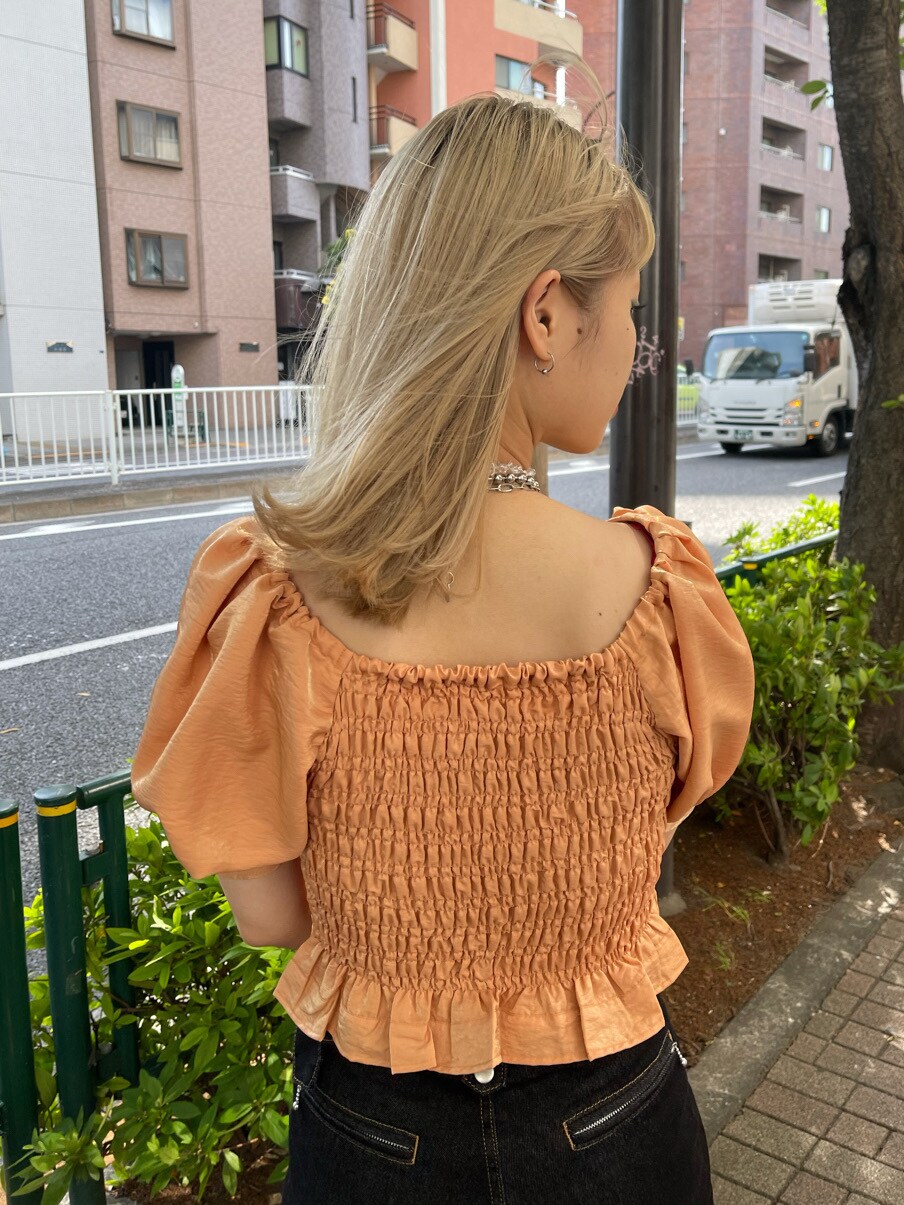 オレンジ系のシャツ/ブラウス、ブラック系のデニムパンツ、ブラック系のハットを着用したレディースの春コーディネートの6枚目の写真