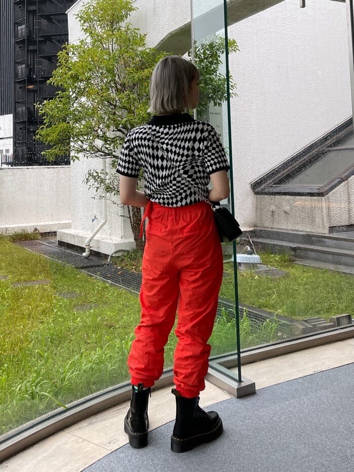 ブラック系のブーツ、ブラック系のニット/セーター、ブラック系のハンドバッグを着用したレディースの春コーディネートの2枚目の写真