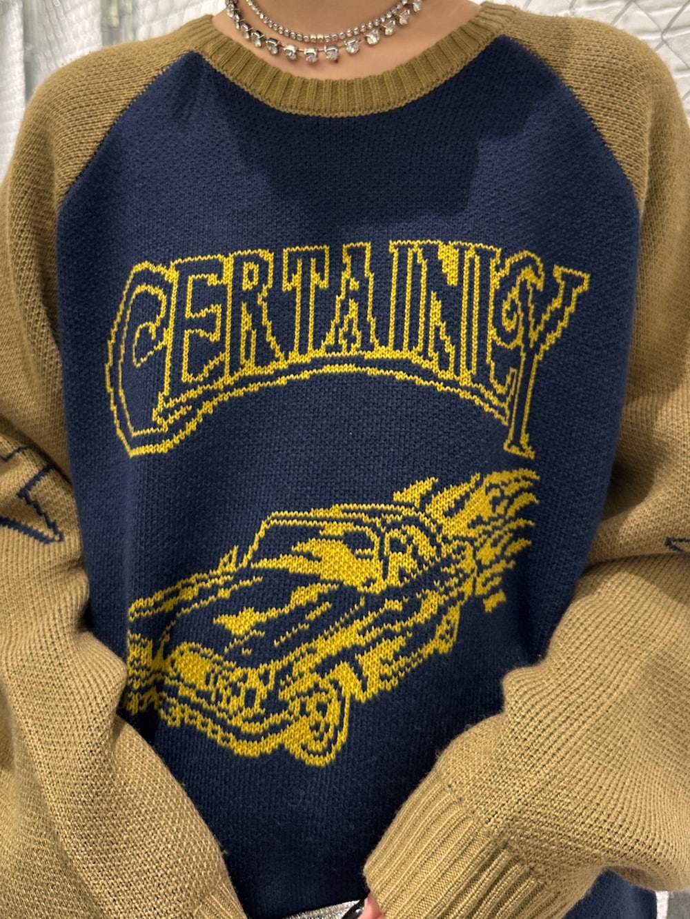 ブルー系のニット/セーター、ホワイト系のスカート、ブラック系のデニムパンツを着用したレディースの冬コーディネートの8枚目の写真