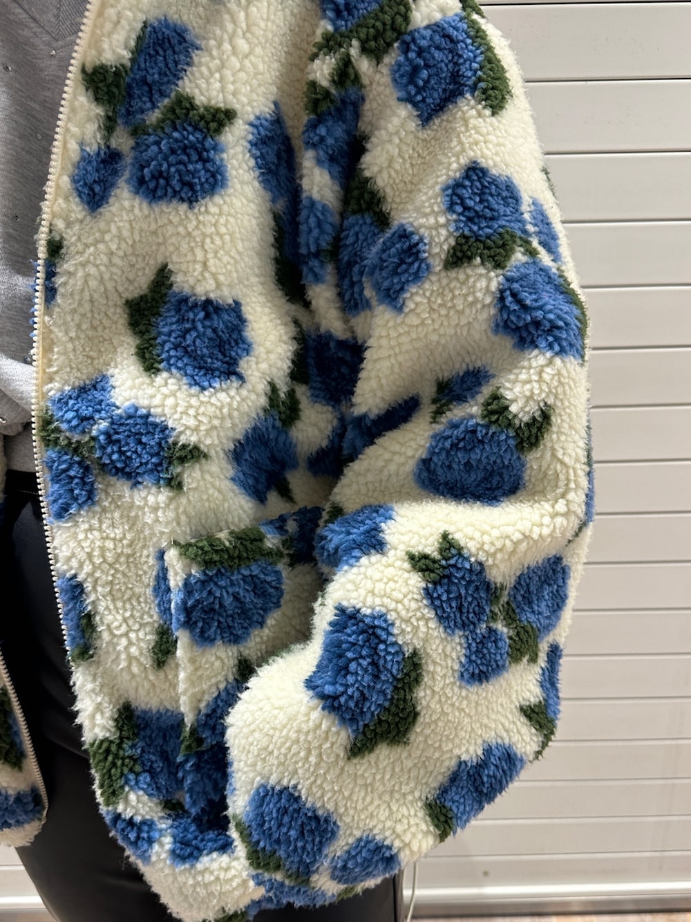 ホワイト系のブルゾン、グレー系のスウェット、ブラック系のその他パンツを着用したレディースの冬コーディネートの7枚目の写真