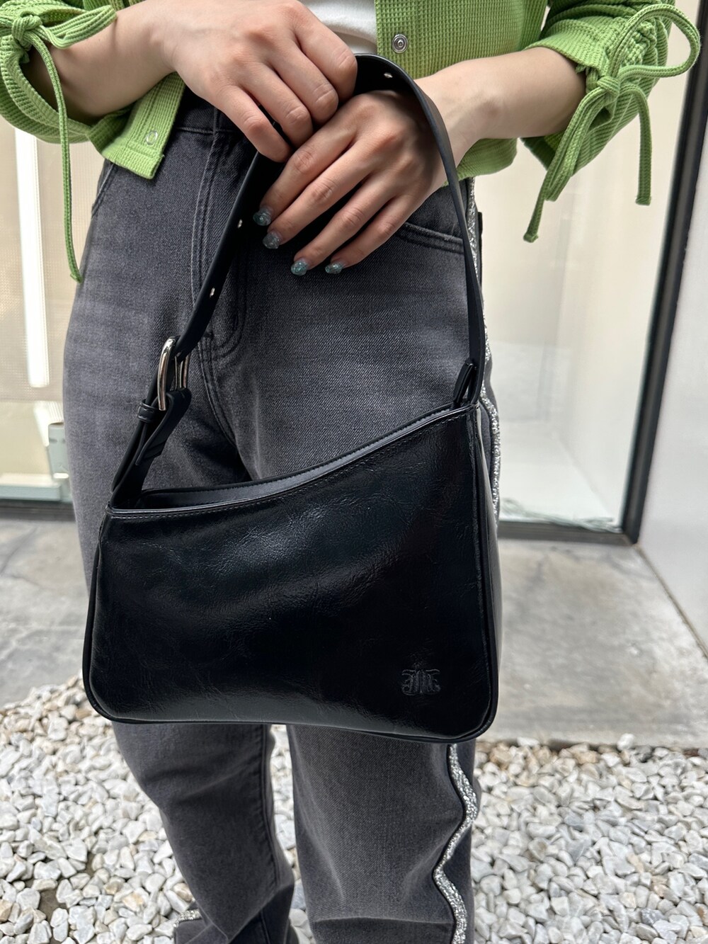 グリーン系のTシャツ/カットソー、ブラック系のデニムパンツ、ブラック系のハンドバッグを着用したレディースの夏コーディネートの9枚目の写真