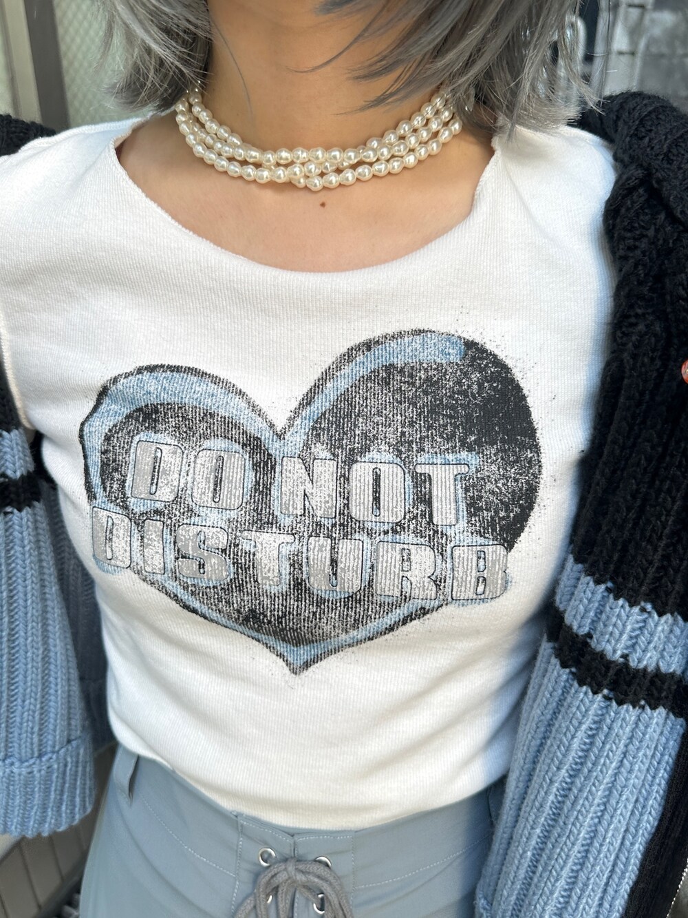 グレー系のその他パンツ、ホワイト系のTシャツ/カットソー、ブラック系のニット/セーターを着用したレディースの秋コーディネートの8枚目の写真