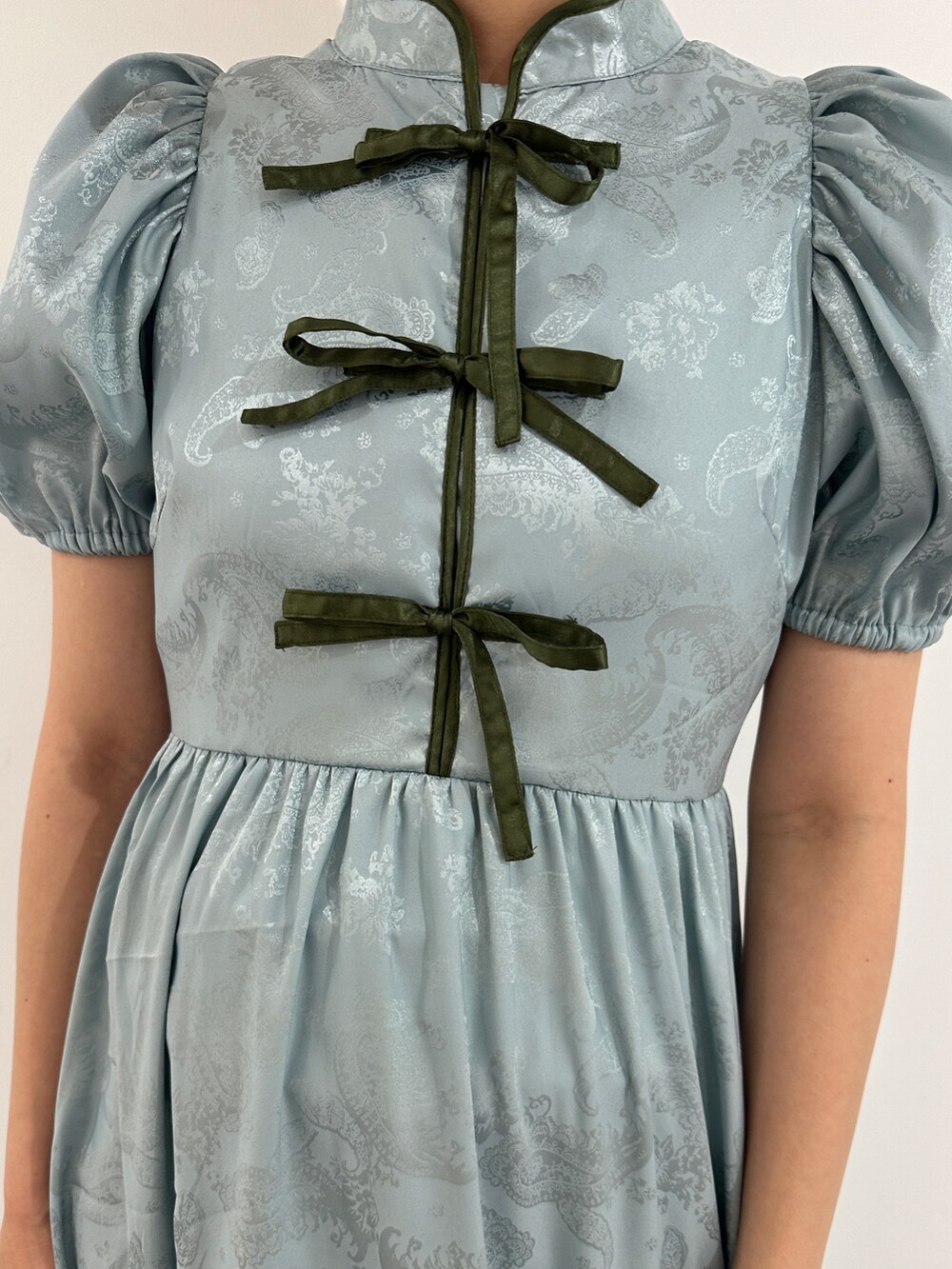 ブルー系のワンピース、ブラック系のブーツを着用したレディースの春コーディネートの5枚目の写真