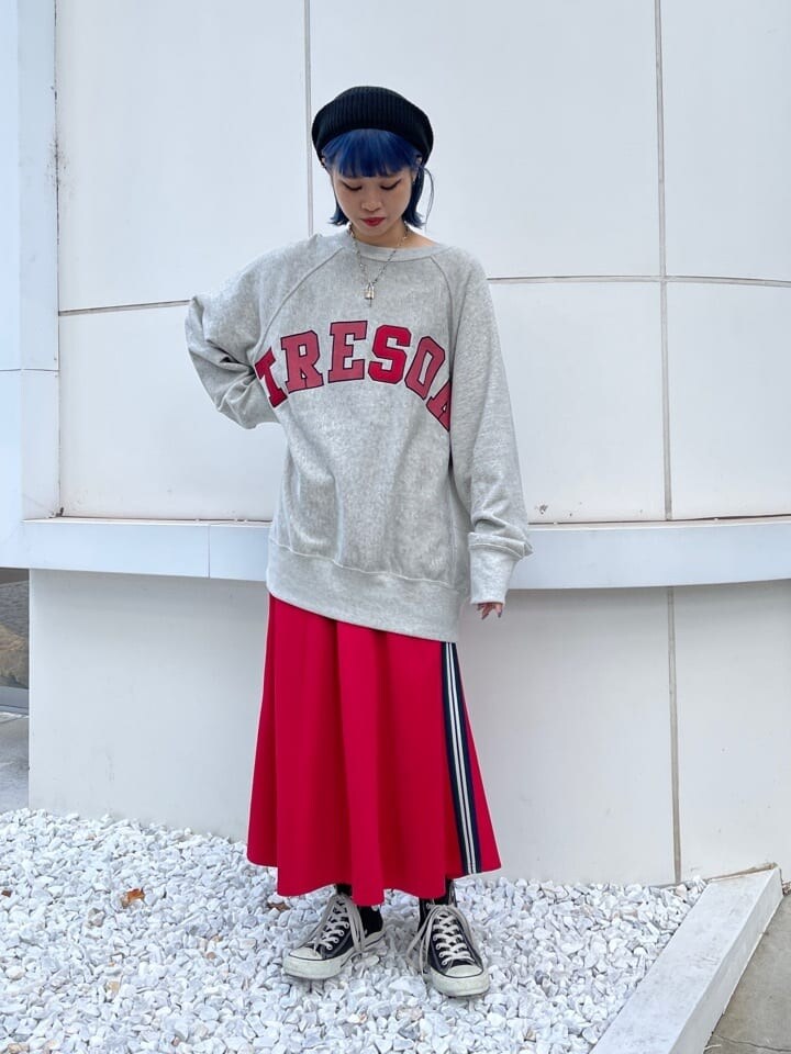 レッド系のスカート、グレー系のスウェット、ブラック系のハンチング/ベレー帽を着用したレディースの秋コーディネートの2枚目の写真