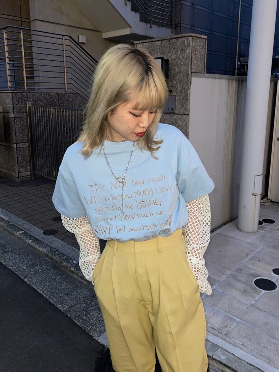 イエロー系のスラックス、ホワイト系のブーツ、ホワイト系のTシャツ/カットソーを着用したレディースの春コーディネートの4枚目の写真