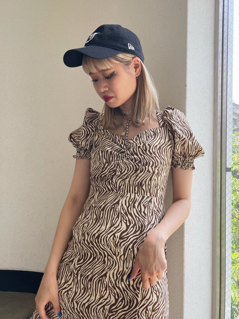 ホワイト系のワンピース、ブラック系のキャップを着用したレディースの春コーディネートの4枚目の写真