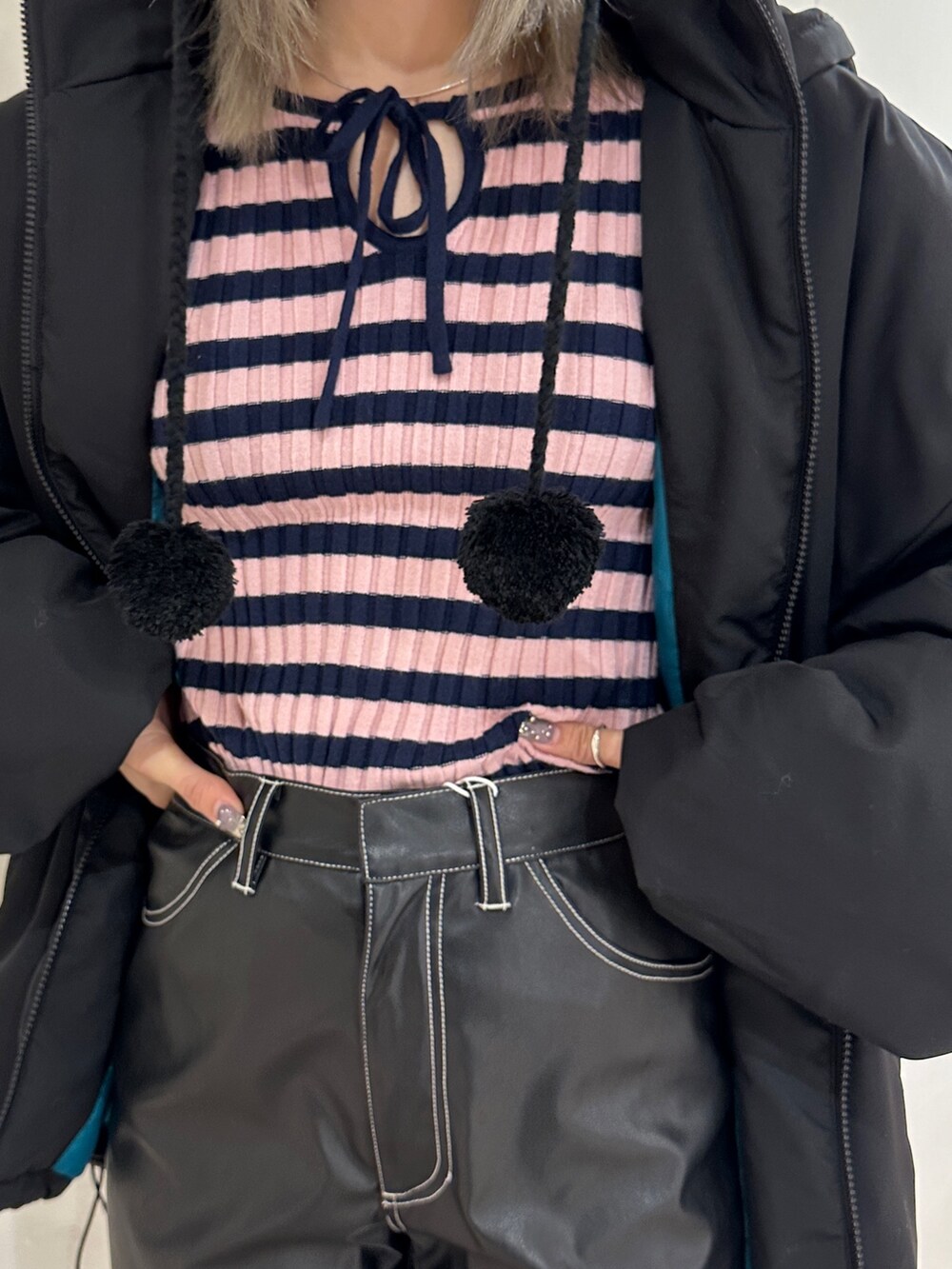 ブラック系のその他パンツ、ブラック系のその他アウター、ピンク系のニット/セーターを着用したレディースの冬コーディネートの7枚目の写真