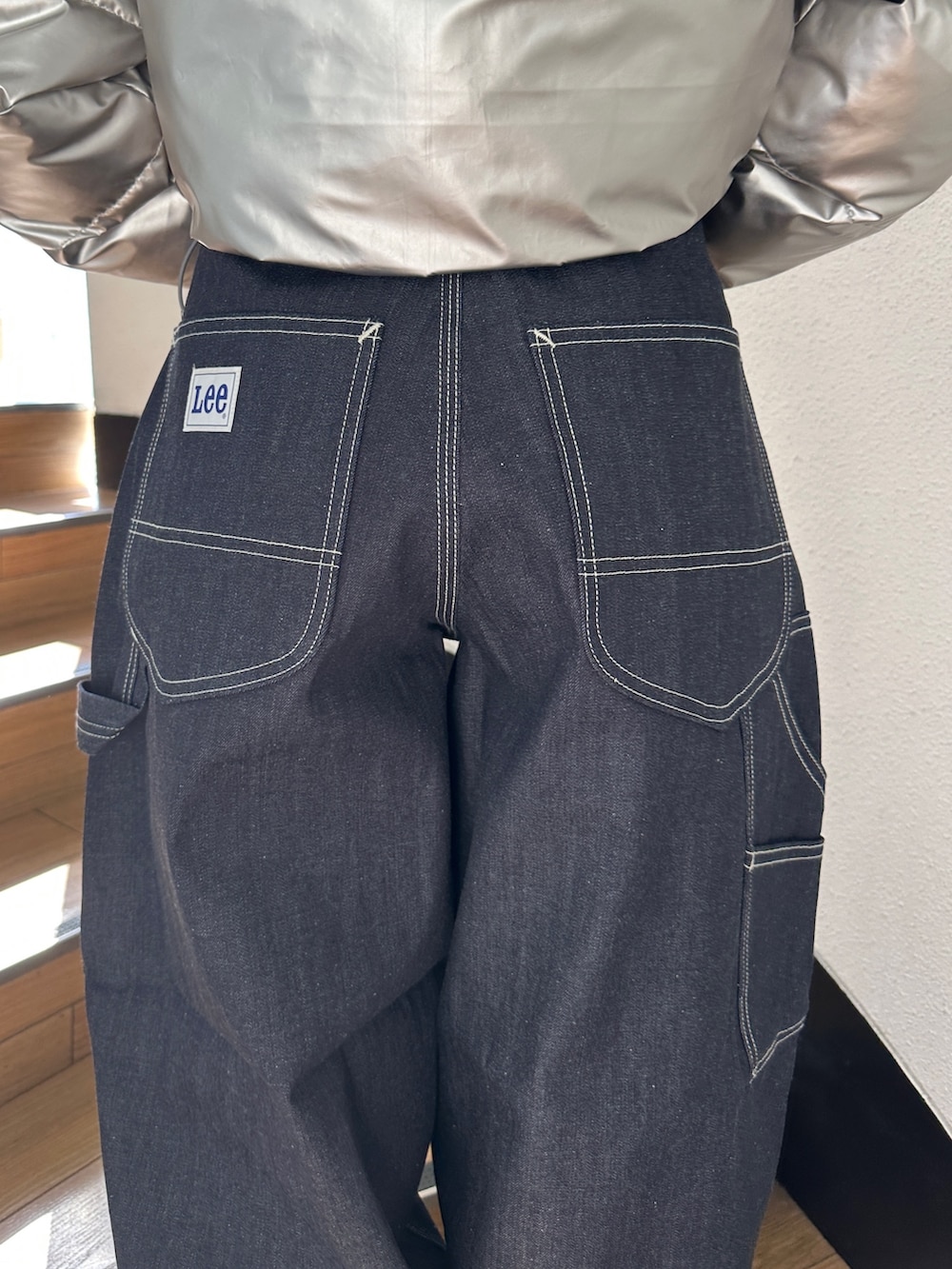 シルバー系のダウンジャケット/コート、ブラック系のTシャツ/カットソー、ブラック系のスニーカーを着用したレディースの秋コーディネートの10枚目の写真