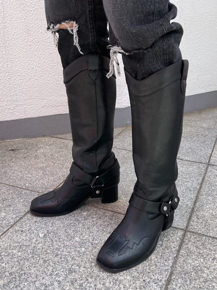 ブラック系のブーツ、ブラック系のデニムパンツ、オレンジ系のカーディガン/ボレロを着用したレディースの夏コーディネートの7枚目の写真