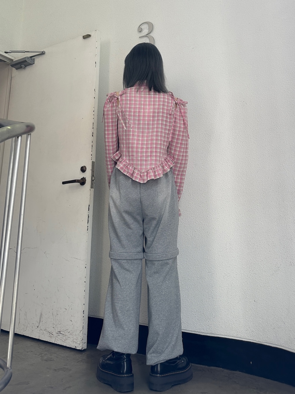 ピンク系のシャツ/ブラウス、グレー系のスウェットパンツ、ブラック系のブーツを着用したレディースの冬コーディネートの2枚目の写真