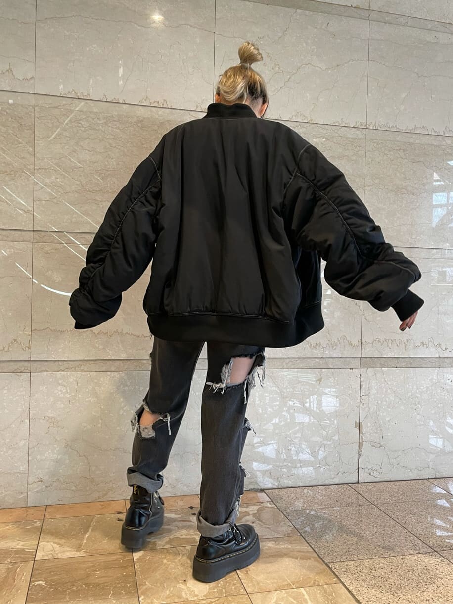 ブラック系のデニムパンツ、ブラック系のTシャツ/カットソー、ブラック系のMA-1を着用したレディースの夏コーディネートの5枚目の写真