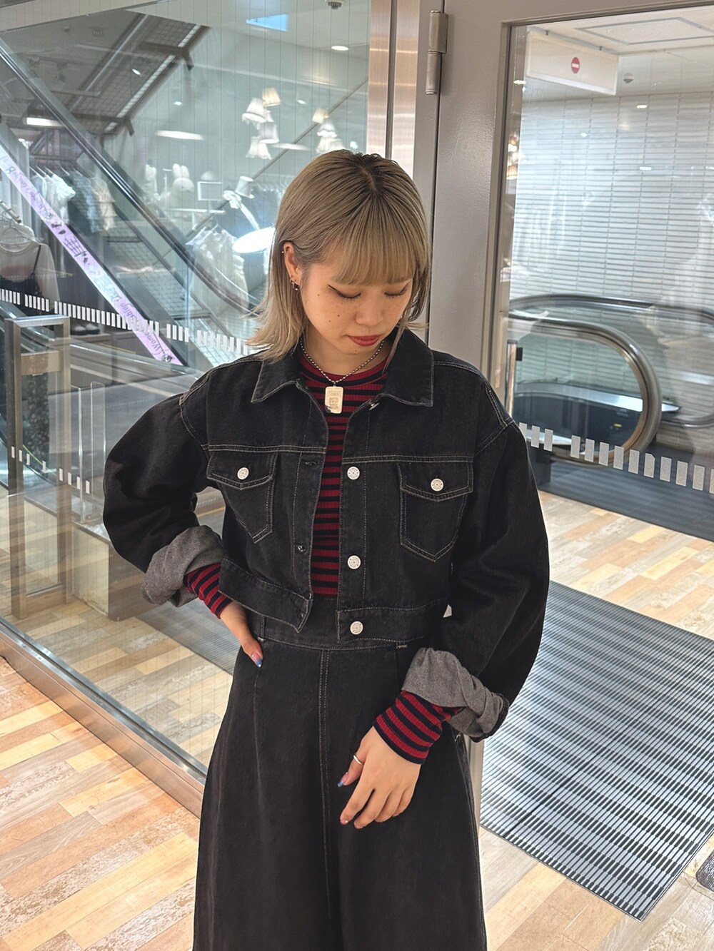 レッド系のTシャツ/カットソー、ブラック系のワンピース、ブラック系のブーツを着用したレディースの夏コーディネートの4枚目の写真