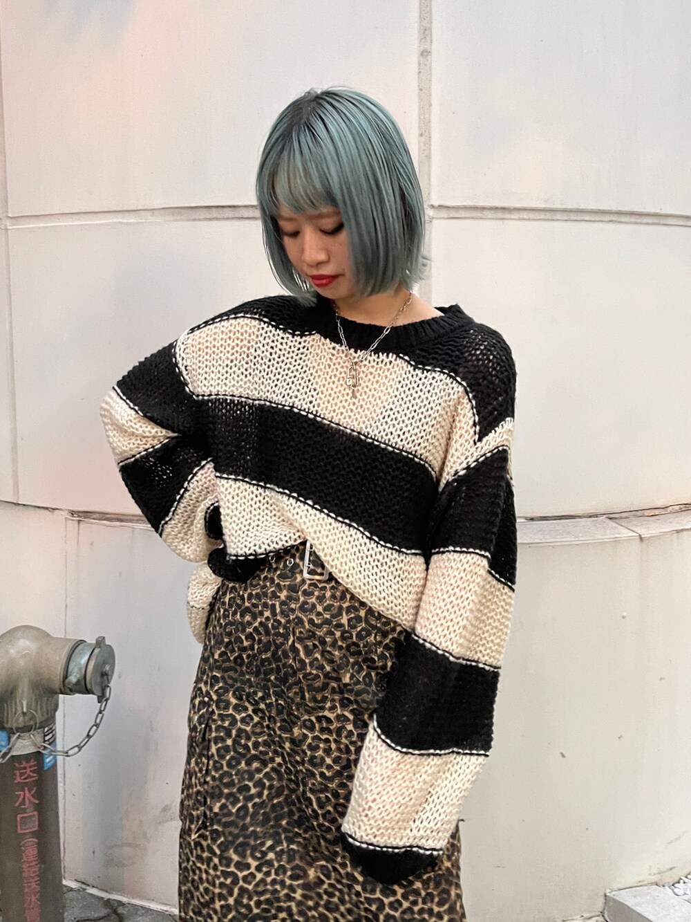 ブラウン系のスカート、ブラック系のニット/セーター、ブラック系のスニーカーを着用したレディースの秋コーディネートの3枚目の写真