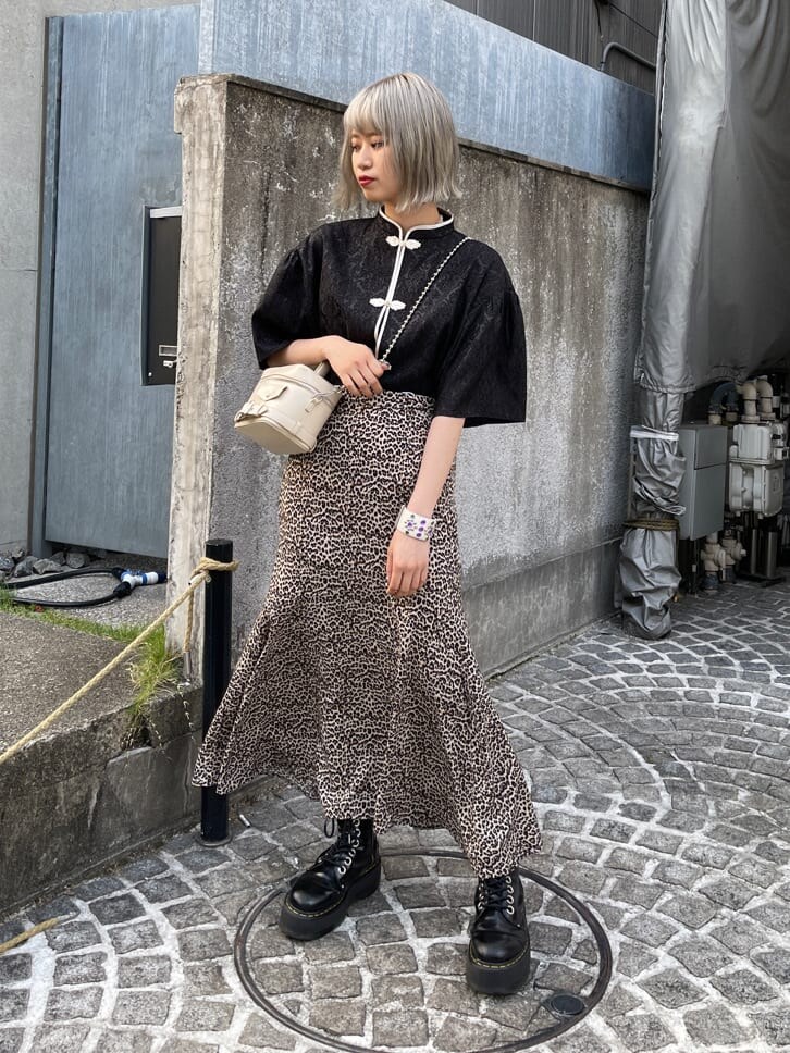 ブラウン系のスカート、ホワイト系のショルダーバッグ、ブラック系のシャツ/ブラウスを着用したレディースの春コーディネートの2枚目の写真