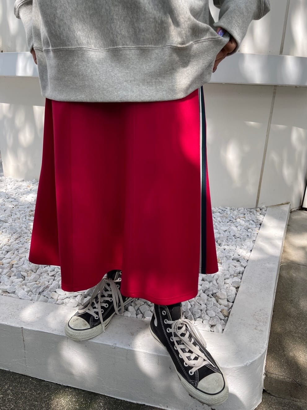 レッド系のスカート、グレー系のスウェット、ブラック系のハンチング/ベレー帽を着用したレディースの秋コーディネートの7枚目の写真