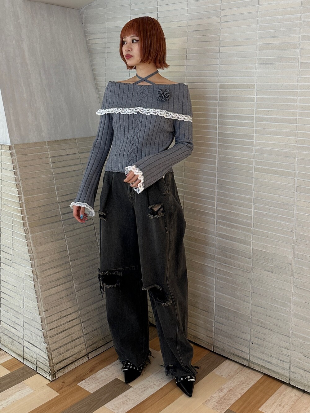 グレー系のニット/セーター、ブラック系のデニムパンツ、ブラック系のブーツを着用したレディースの冬コーディネートの3枚目の写真