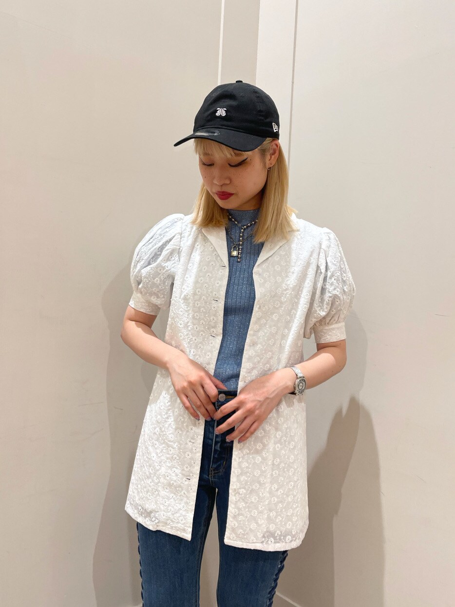 ブラック系のブーツ、ホワイト系のワンピース、ブルー系のデニムパンツを着用したレディースの春コーディネートの2枚目の写真