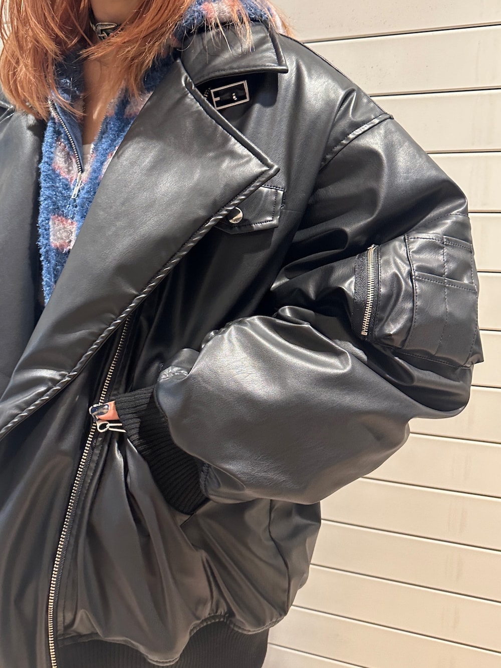 ブラック系のブルゾン、ブルー系のパーカー、ブルー系のデニムパンツを着用したレディースの秋コーディネートの8枚目の写真