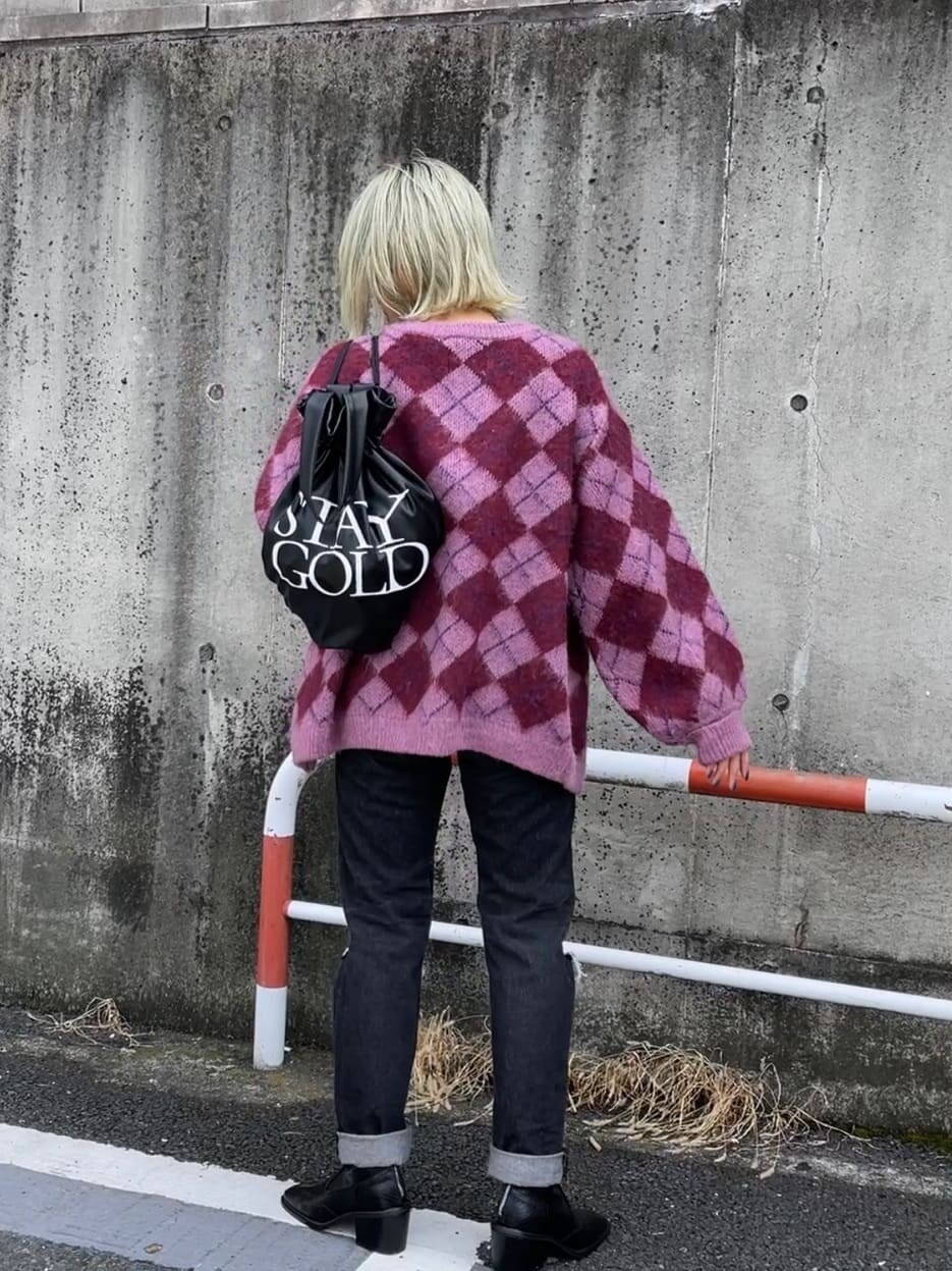ブラック系のバックパック/リュック、ピンク系のカーディガン/ボレロ、ブラック系のブーツを着用したレディースの秋コーディネートの3枚目の写真