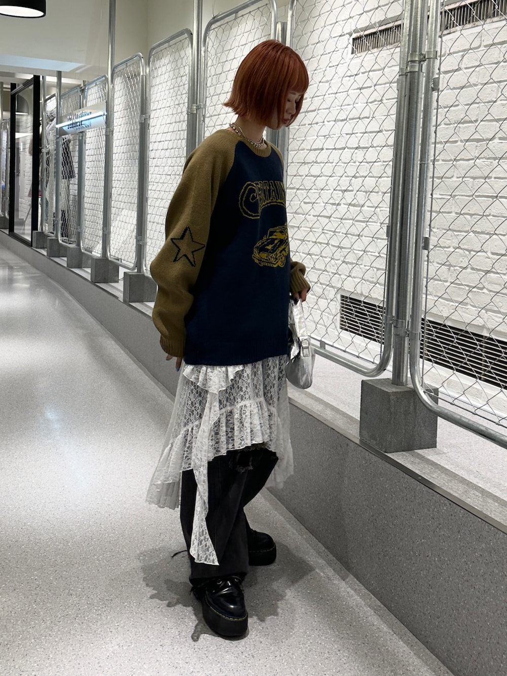 ブルー系のニット/セーター、ホワイト系のスカート、ブラック系のデニムパンツを着用したレディースの冬コーディネートの4枚目の写真