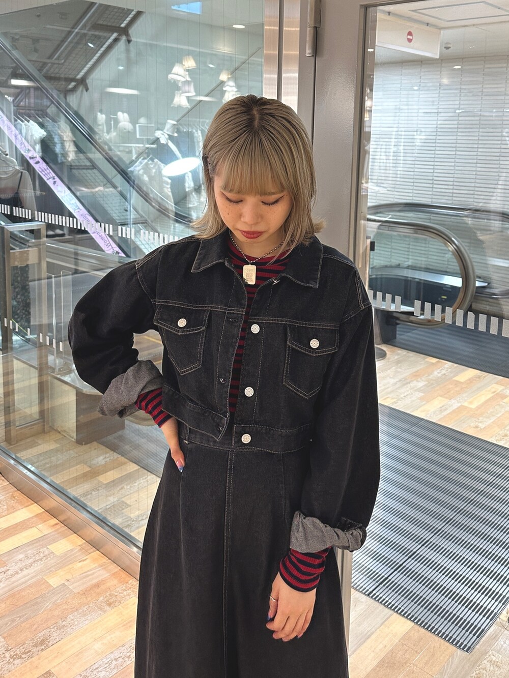 レッド系のTシャツ/カットソー、ブラック系のワンピース、ブラック系のブーツを着用したレディースの夏コーディネートの5枚目の写真