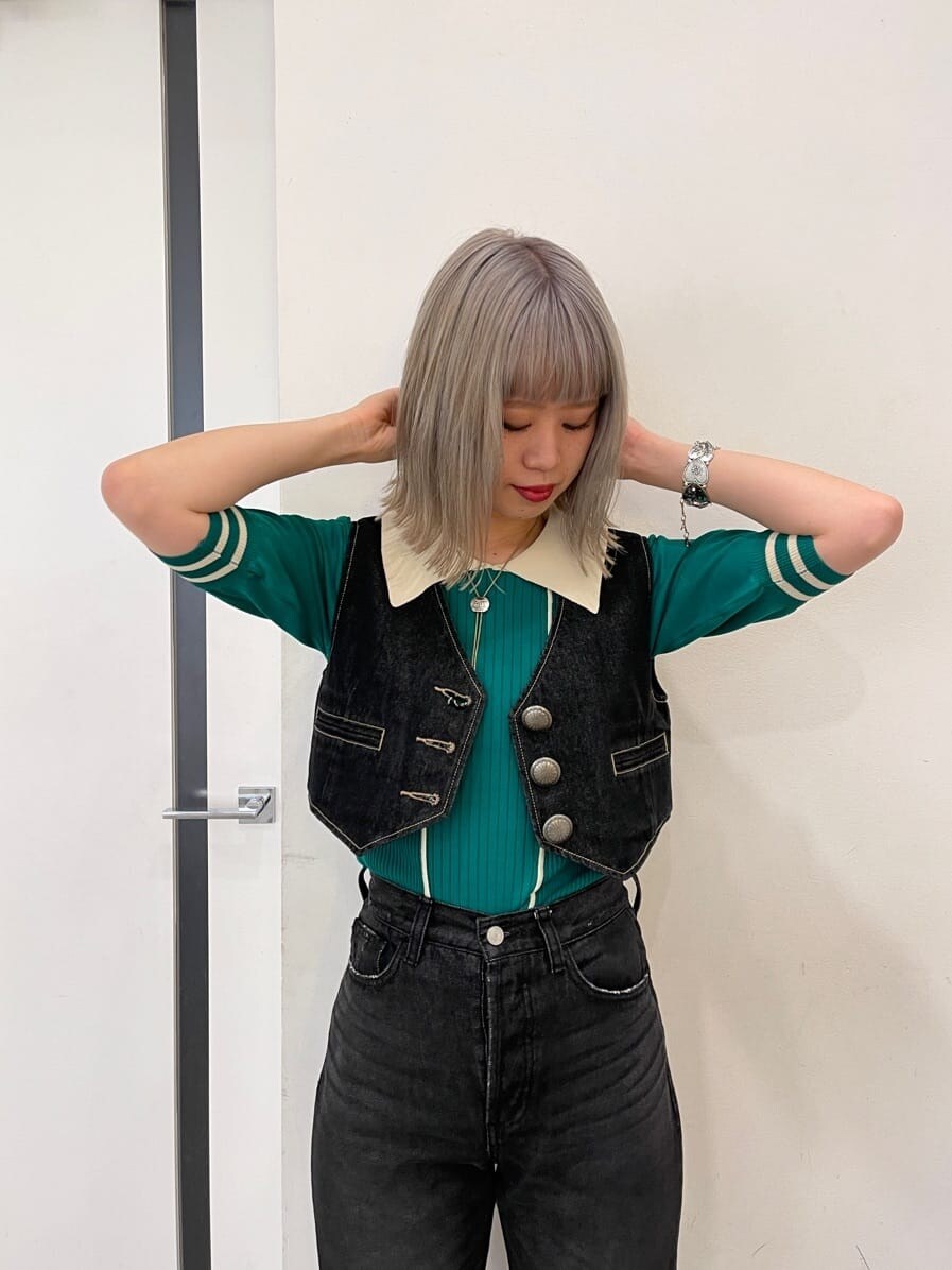 ブラック系のデニムパンツ、ブラック系のブーツ、ブラック系のベストを着用したレディースの春コーディネートの4枚目の写真