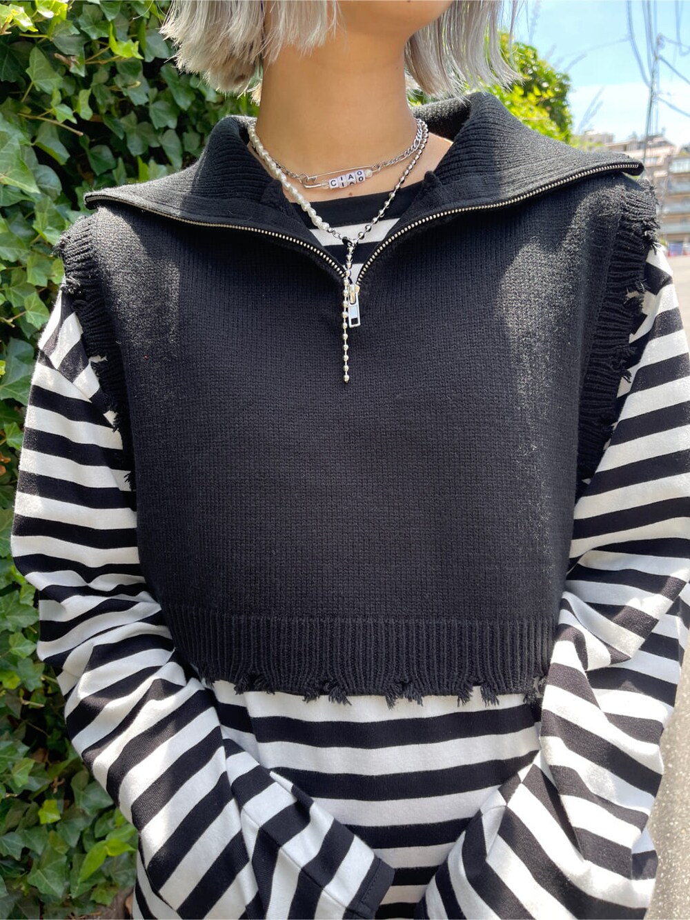 ピンク系のスラックス、ホワイト系のボストンバッグ、ブラック系のベストを着用したレディースの夏コーディネートの8枚目の写真