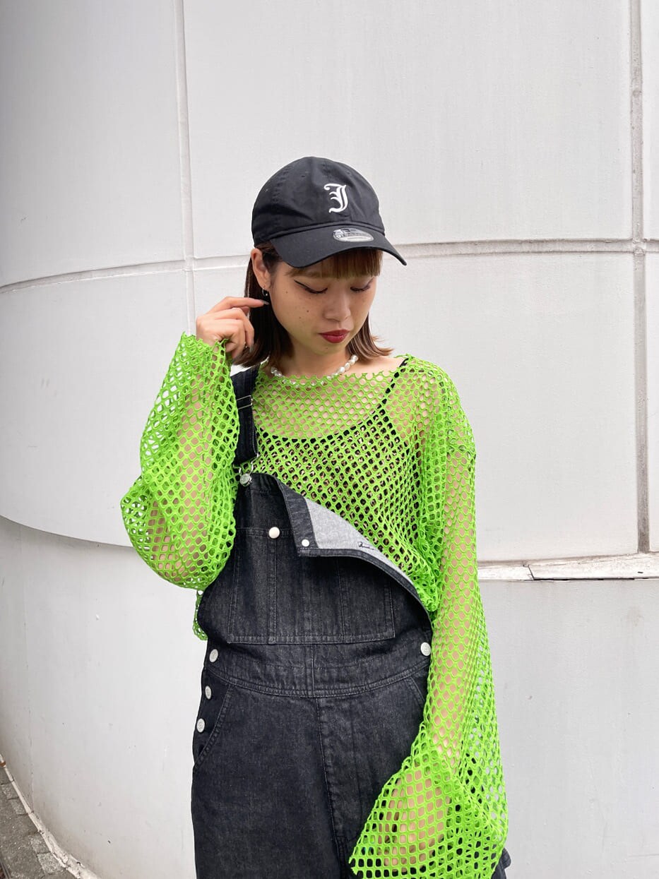 ブラック系のサロペット/オーバーオール、グリーン系のTシャツ/カットソー、ブラック系のキャップを着用したレディースの冬コーディネートの5枚目の写真