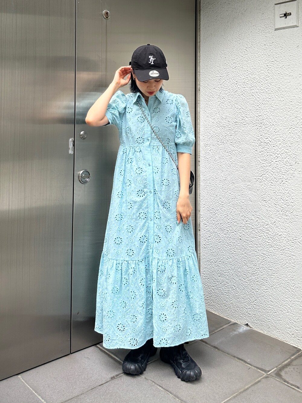 ブルー系のワンピース、ブラック系のスニーカー、ブラック系のキャップを着用したレディースの夏コーディネートの4枚目の写真