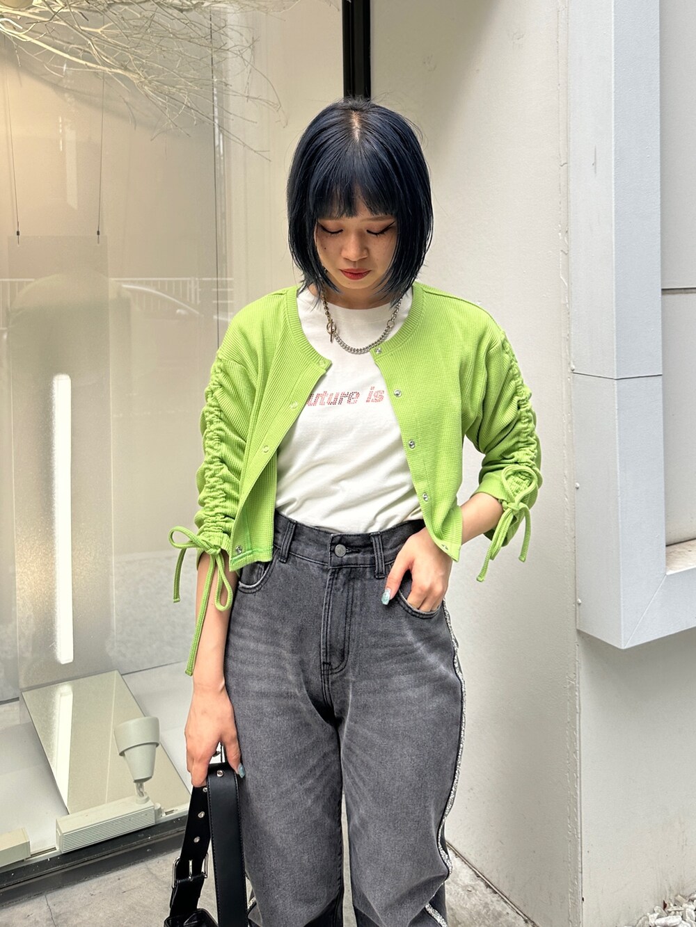 グリーン系のTシャツ/カットソー、ブラック系のデニムパンツ、ブラック系のハンドバッグを着用したレディースの夏コーディネートの5枚目の写真