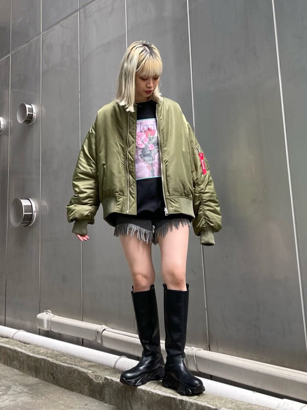 ブラック系のデニムパンツ、ベージュ系のMA-1、ブラック系のブーツを着用したレディースの秋コーディネートの3枚目の写真