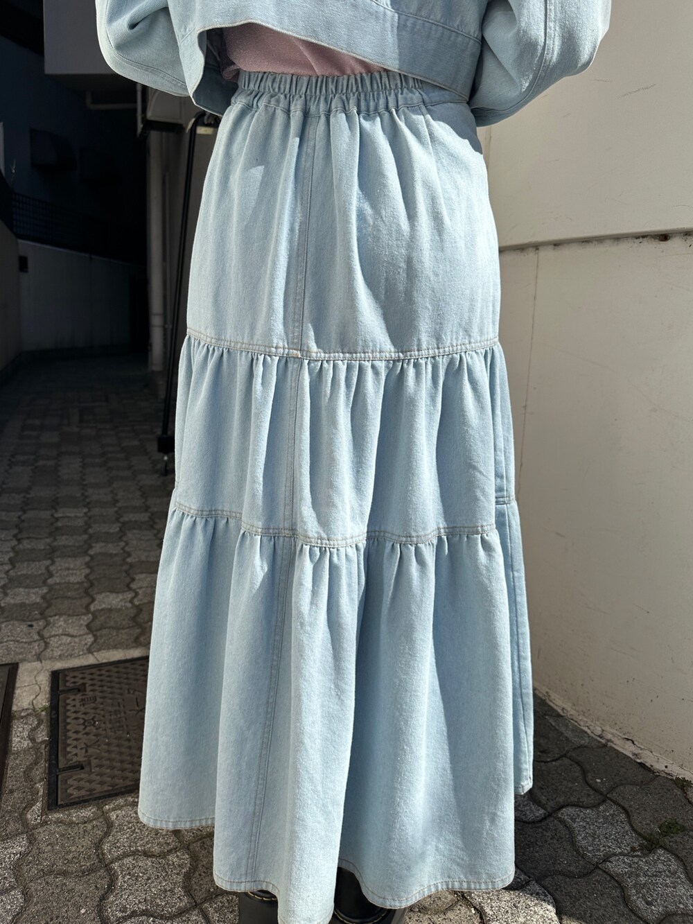 ブルー系のワンピース、ピンク系のTシャツ/カットソー、ブラック系のブーツを着用したレディースの冬コーディネートの10枚目の写真