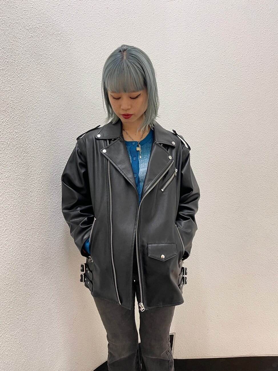 ブラック系のブーツ、ブラック系のライダースジャケット、ブルー系のカーディガン/ボレロを着用したレディースの秋コーディネートの6枚目の写真