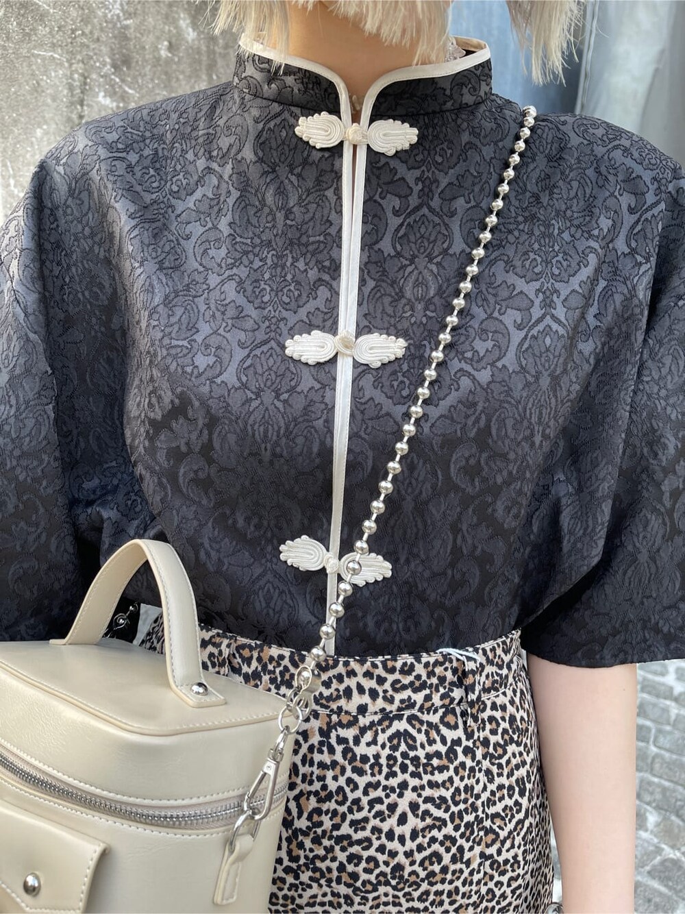 ブラウン系のスカート、ホワイト系のショルダーバッグ、ブラック系のシャツ/ブラウスを着用したレディースの春コーディネートの6枚目の写真